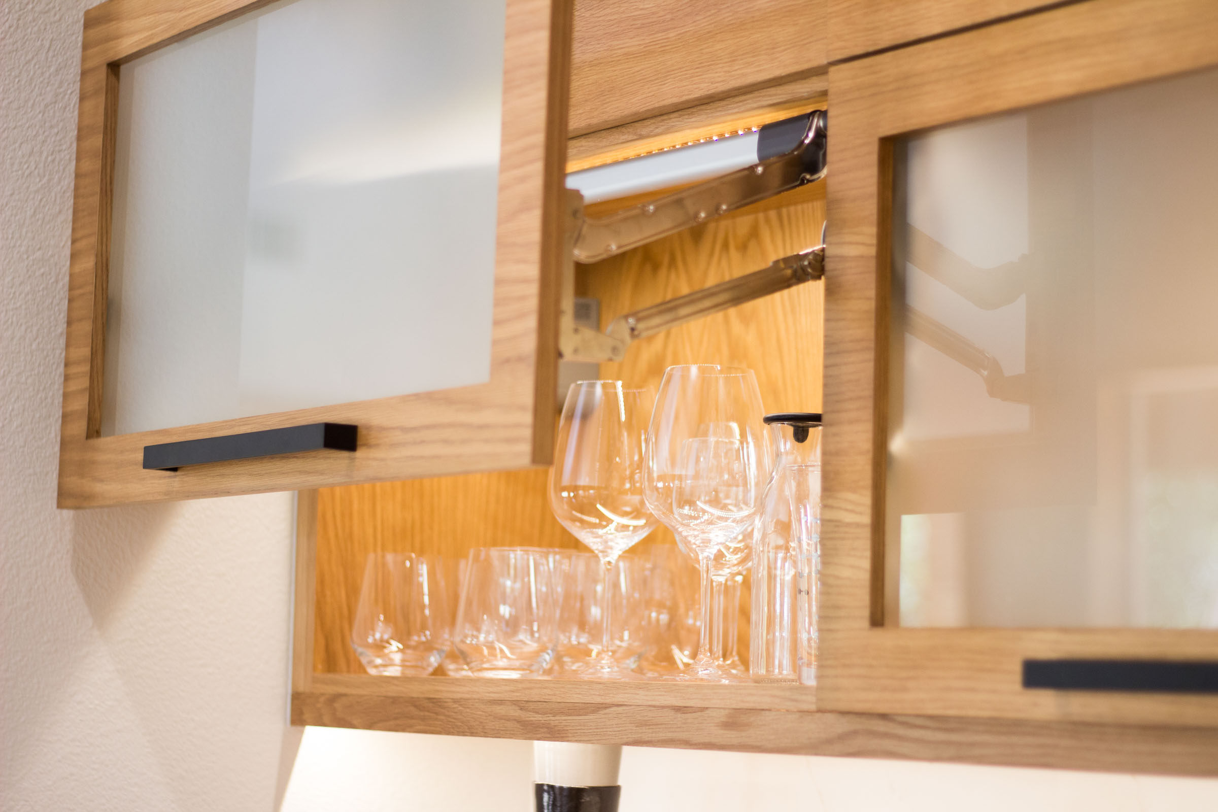 Wine glasses, frosted glass cabinet, vertical lift cabinet door, blonde wood