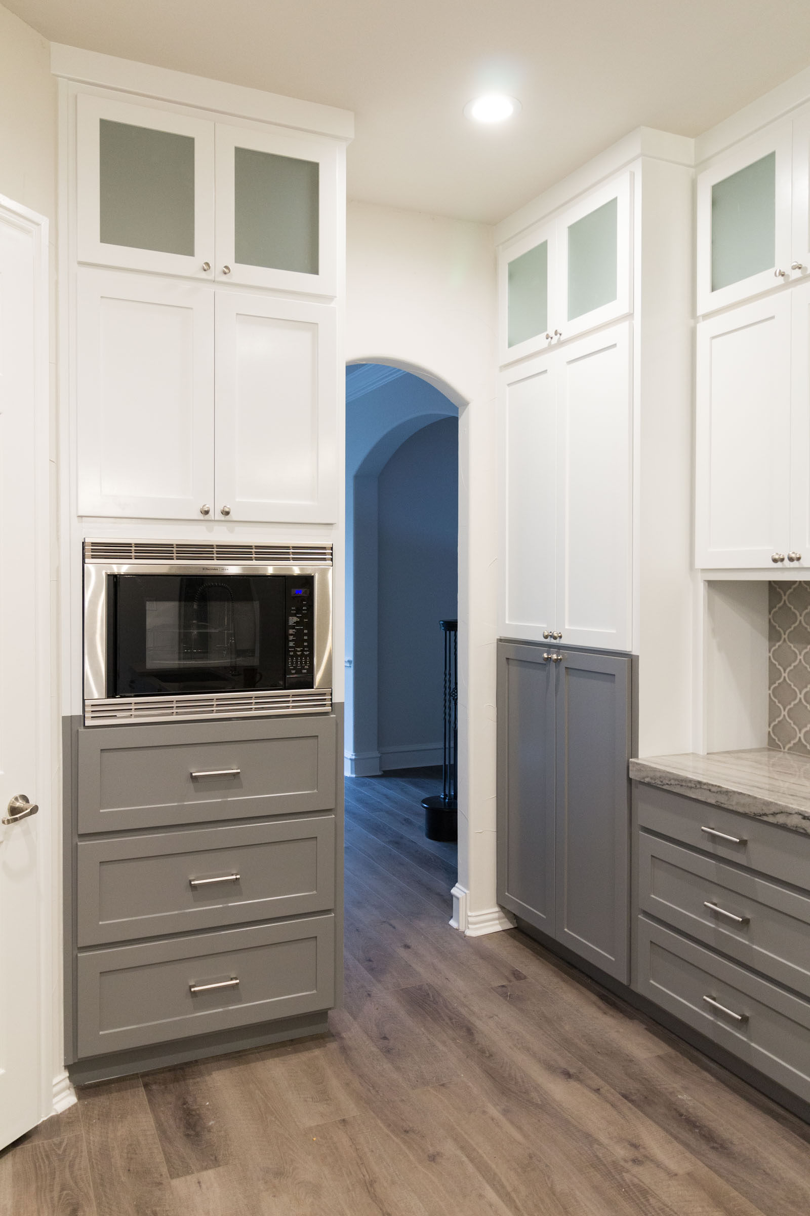 Contemporary kitchen remodel with grey and white cabinets, frosted glass, arabesque tile