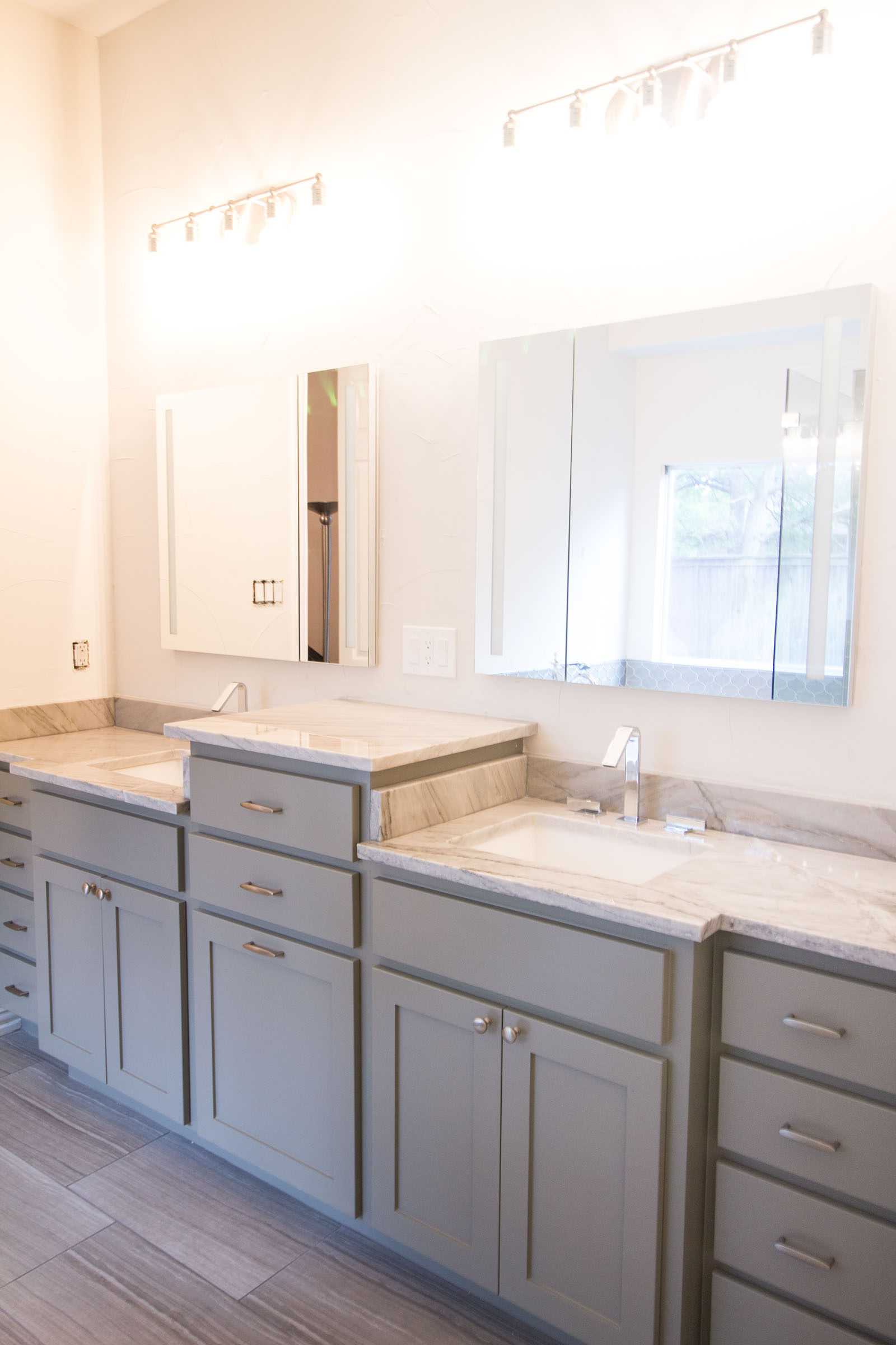 Contemporary bathroom remodel, grey cabinets, bright lighting, lots of counter space