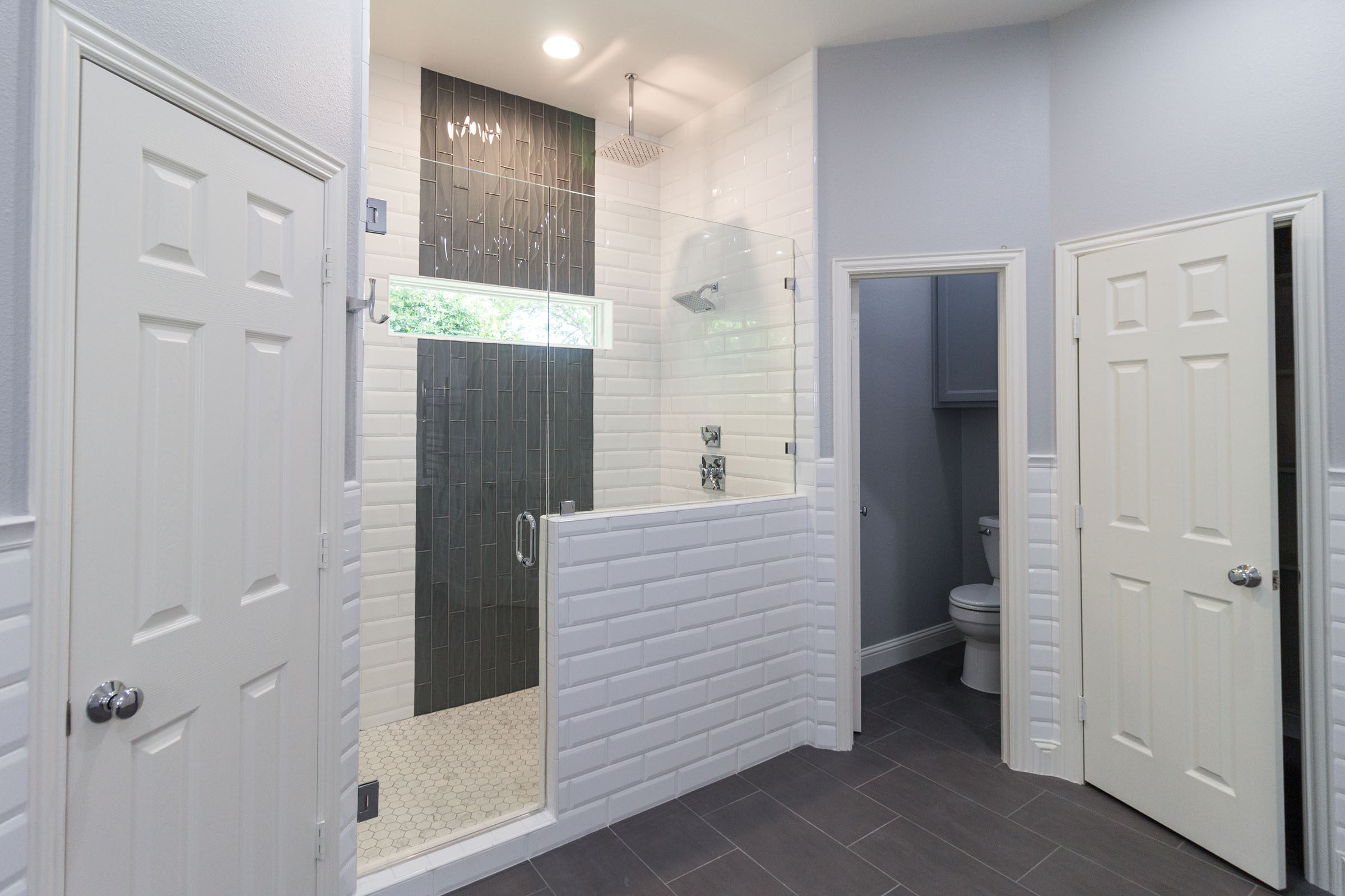 Contemporary bathroom remodel, grey and white, subway tile, grey flooring, toilet closet, walk in shower, chrome shower head