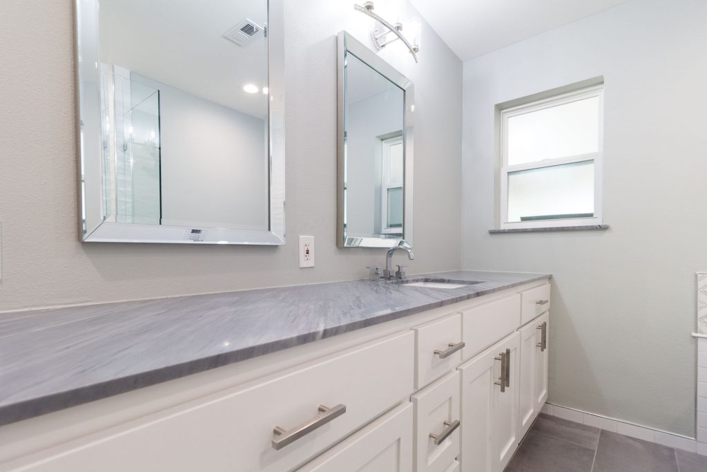 Bathroom remodel, twin mirrors, white shaker cabinets, grey granite, window, dark grey tile