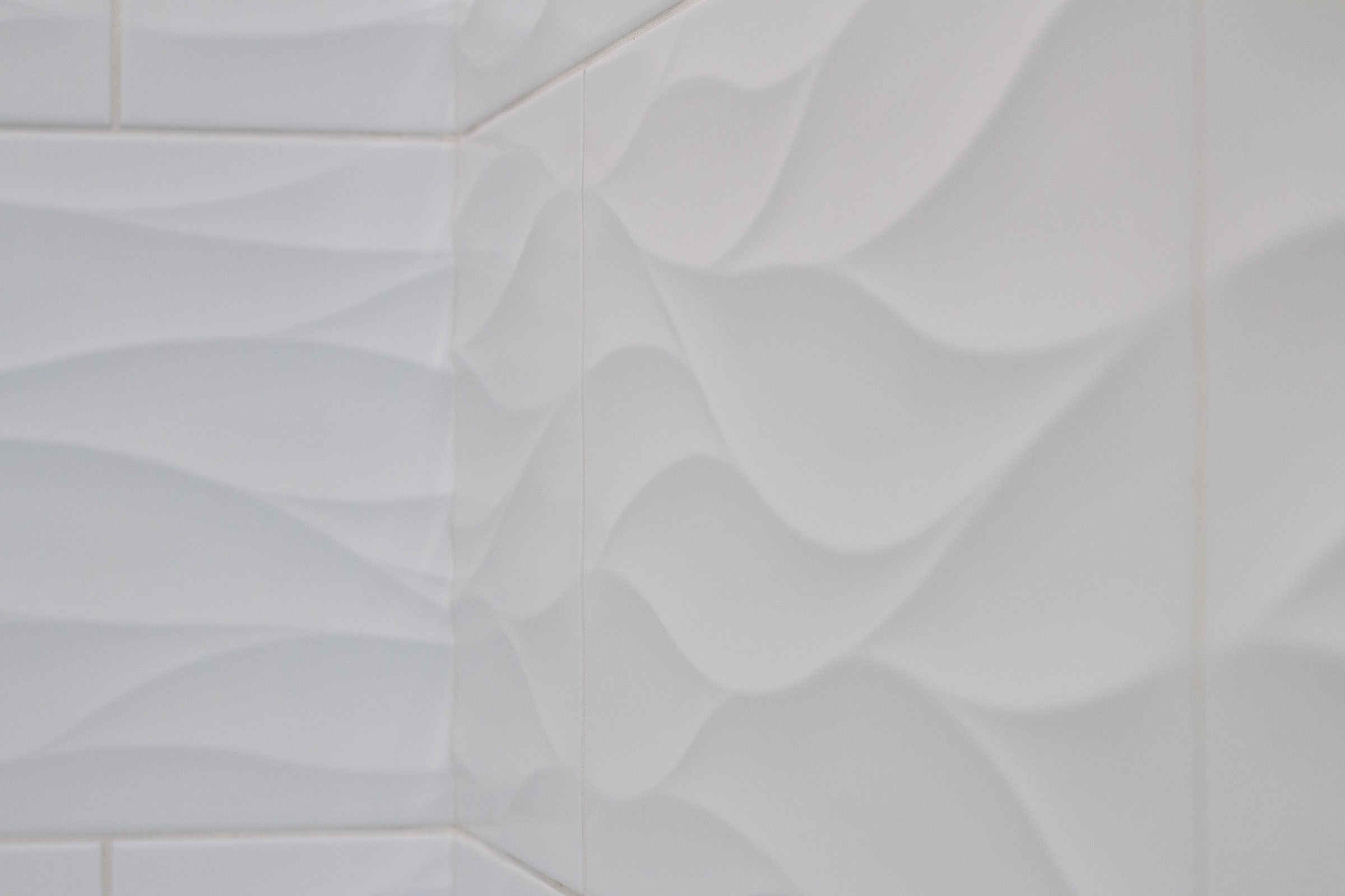 Close up of white shower tile with wavy texture