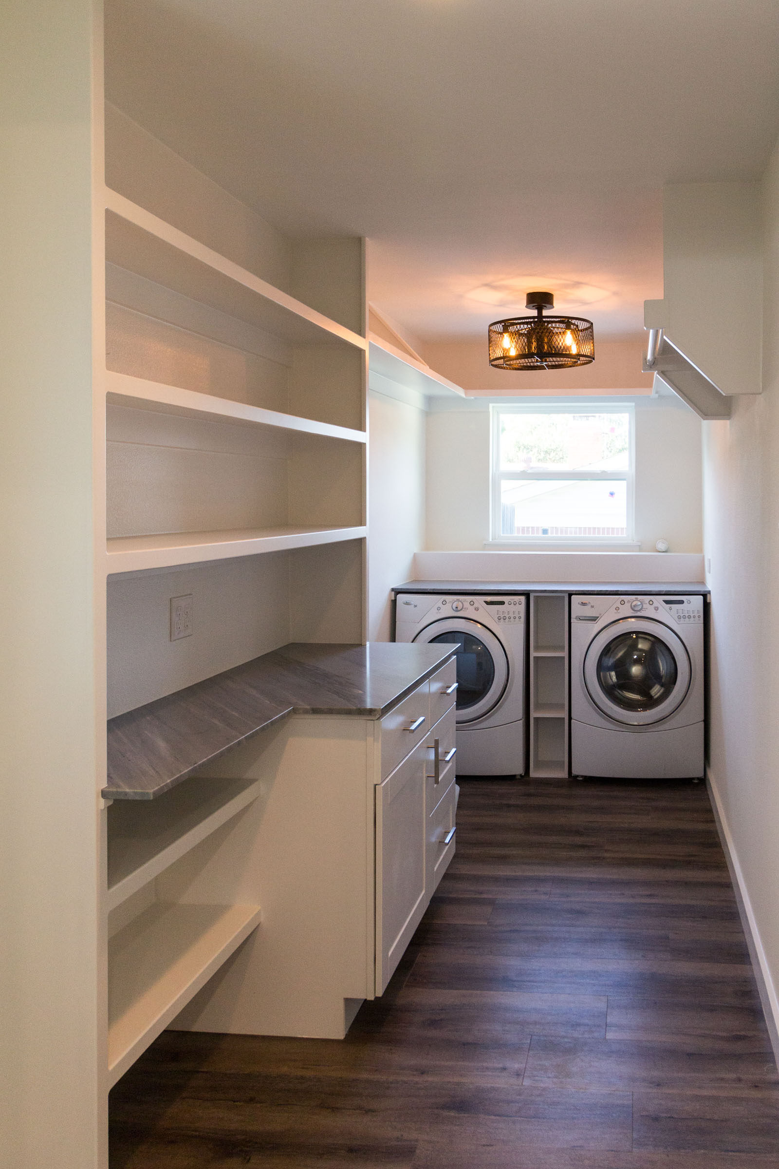 Laundry room built in shelves with folding counter and wood floors