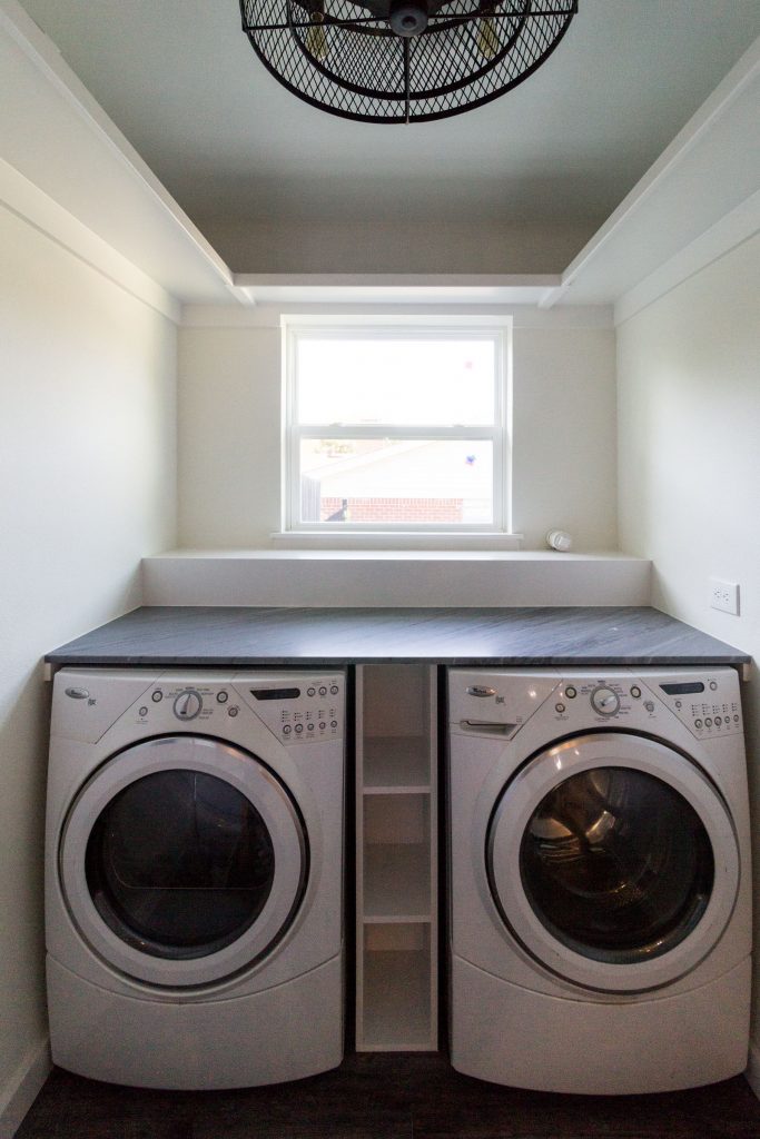 New laundry room, clean, minimalistic, white, washer and dryer, folding counter, window, built in storage