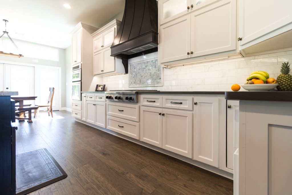 Custom kitchen, shaker style cabinets, espresso vent hood, backsplash, hardwood flooring, fruit, black granite, grey and white neutral color scheme